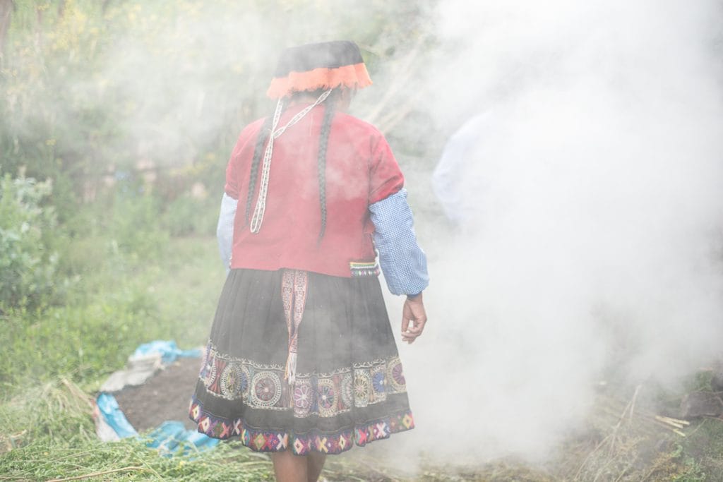 Pachamanca Dining Experience in Peru - Woman preparing the Pachamanca amidst Steam