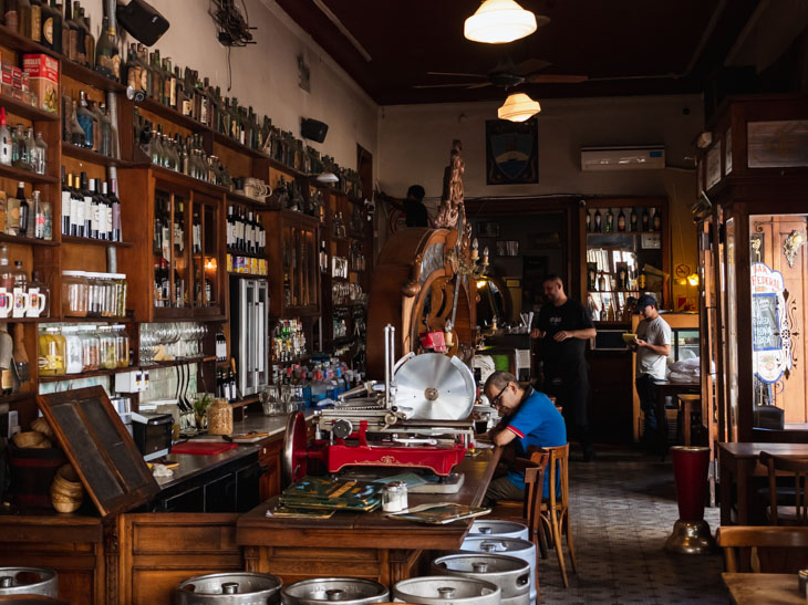 A man sits at the bar of an old mahogany bar in El Federal, Buenos Aires, Argentina