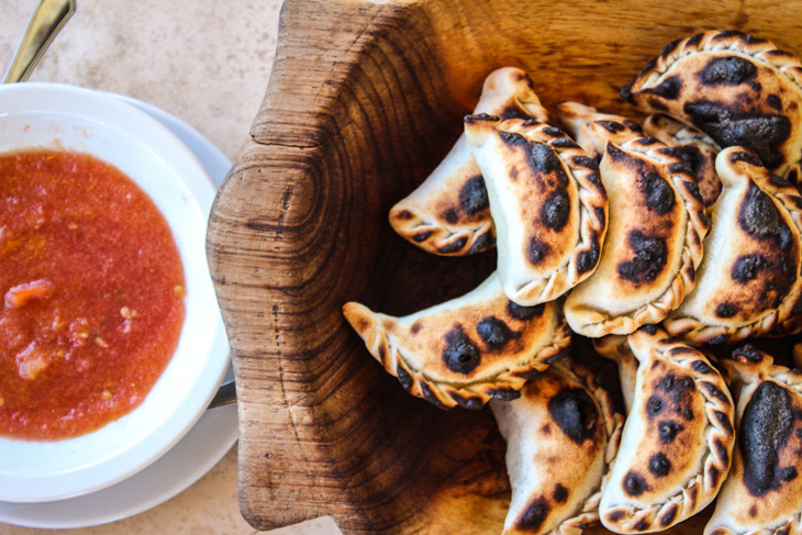 A plate of empanadas next to some salsa, Salta, Argentina