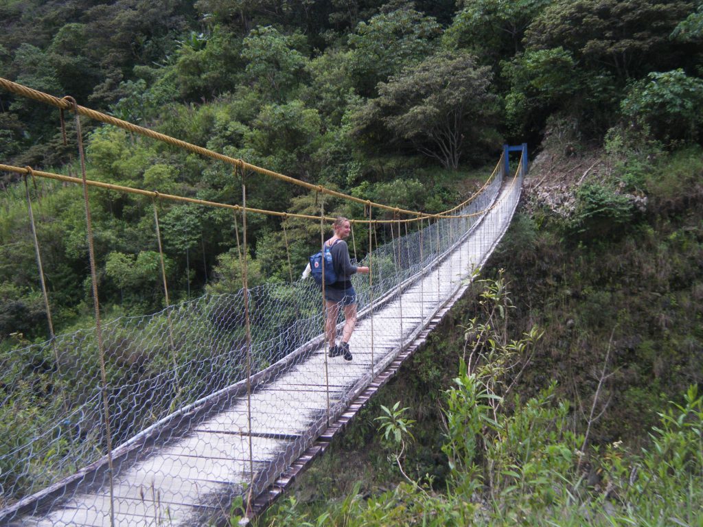 Inca Jungle Trail - Hiker crossing rickety footbridge.