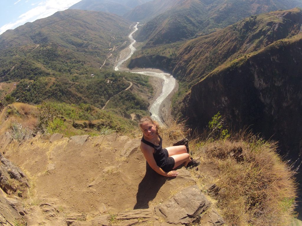 Inca Jungle Trail - Hiker on cliff ledge with spectacular views behind.