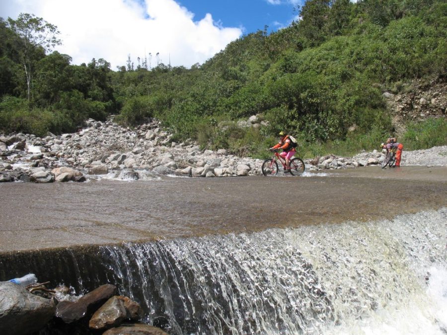 Inca Jungle Trail - Cyclist rides through a river.