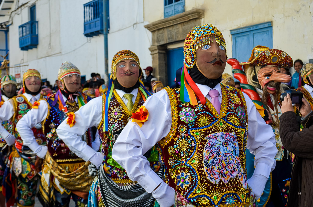 Performers in colorful costumes and masks at the Virgin del Carmen Festival