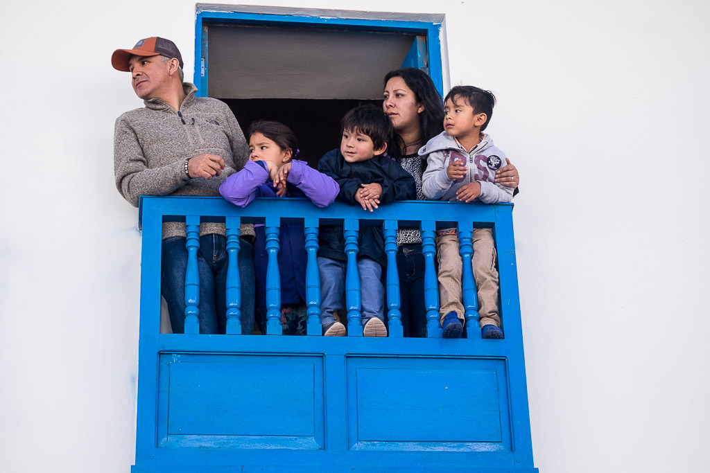 Spectators watch the festivities from a local balcony