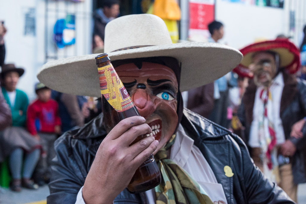 A masked Spanish conquistador holding a beer