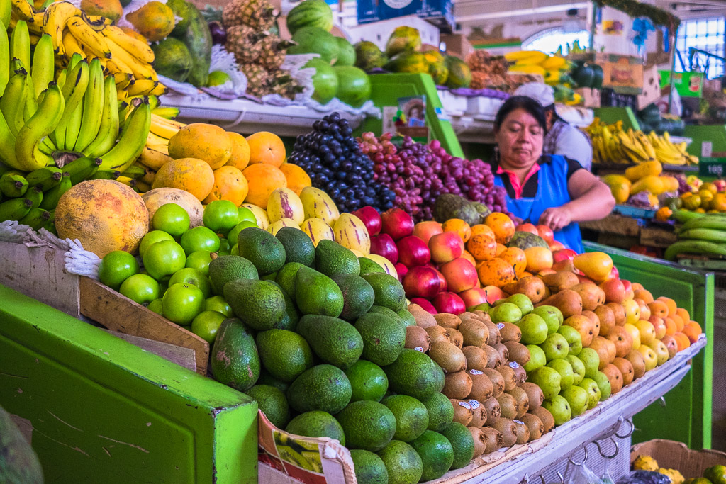 A woman sells fruits at a market in Ecuador.