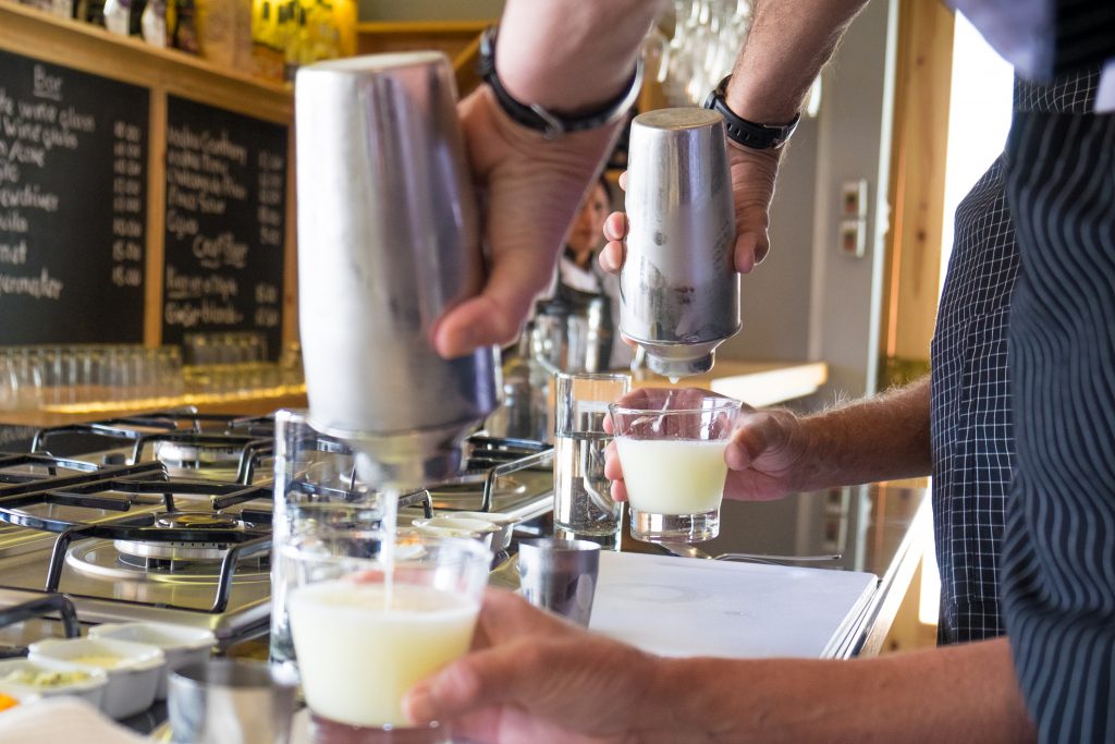 Cooking class in Cusco - Pouring pisco sours from cocktail shakers.