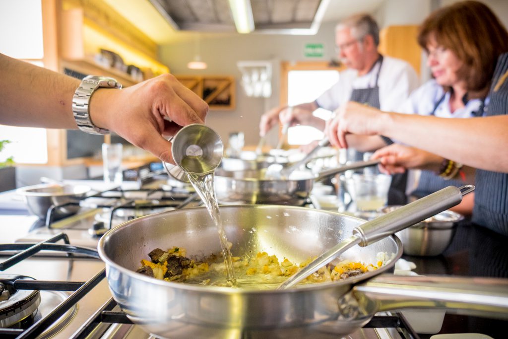 Cooking class in Cusco - Pouring wine into a frypan.